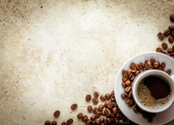 Concrete background with rough texture. White cup on saucer with black coffee and roasted beans with copy space and light vignette. Mockup template with fresh morning espresso in corner