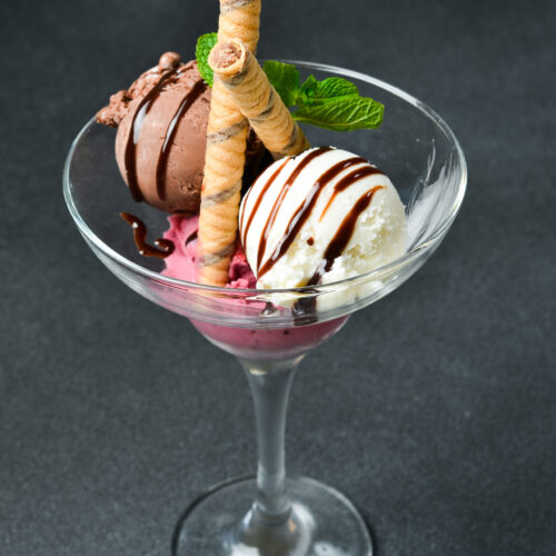 Chocolate ice cream with fruit in a glass. Free space for text. Close up.